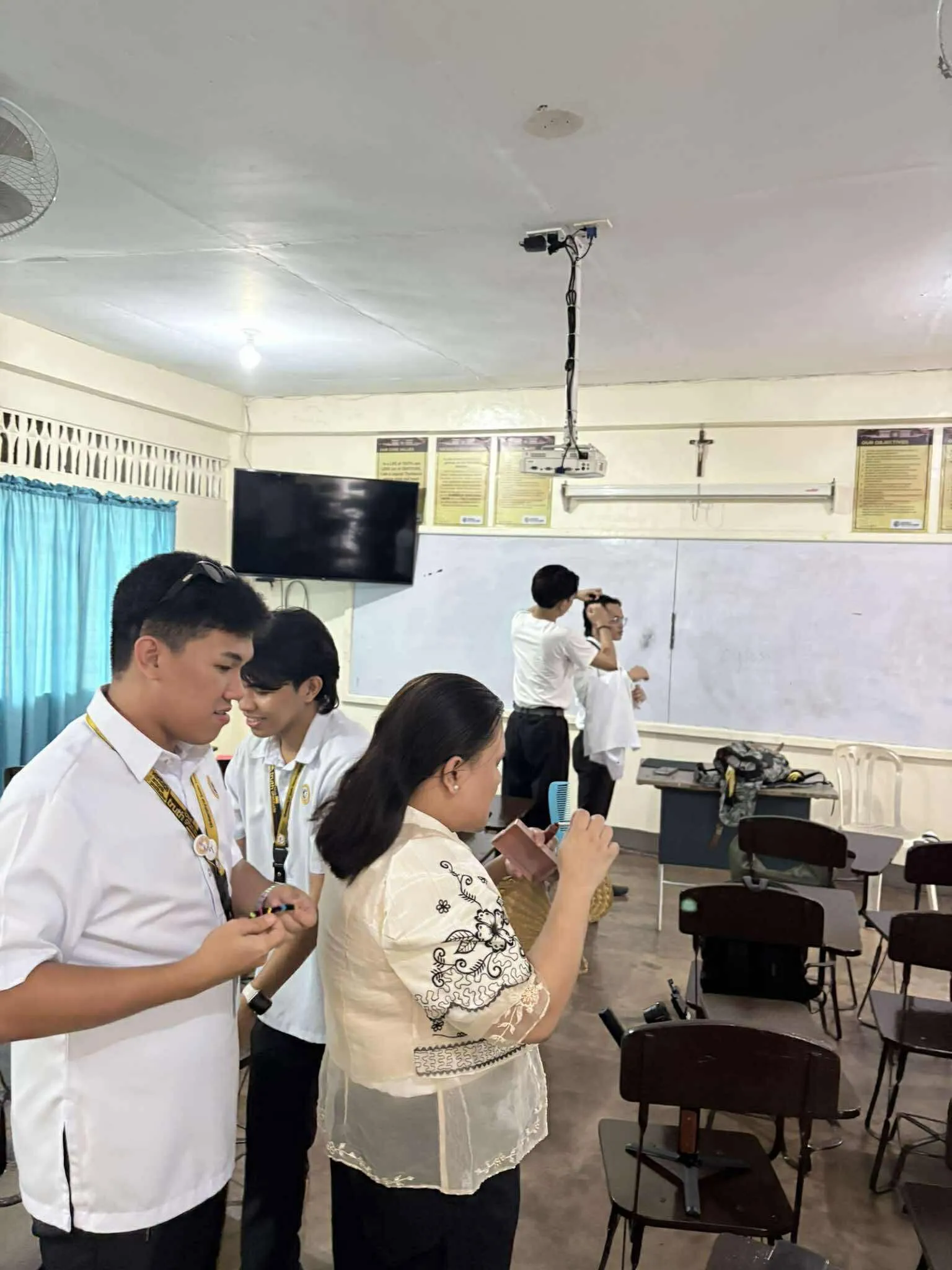 Crew and cast going over a scene in a classroom set.
