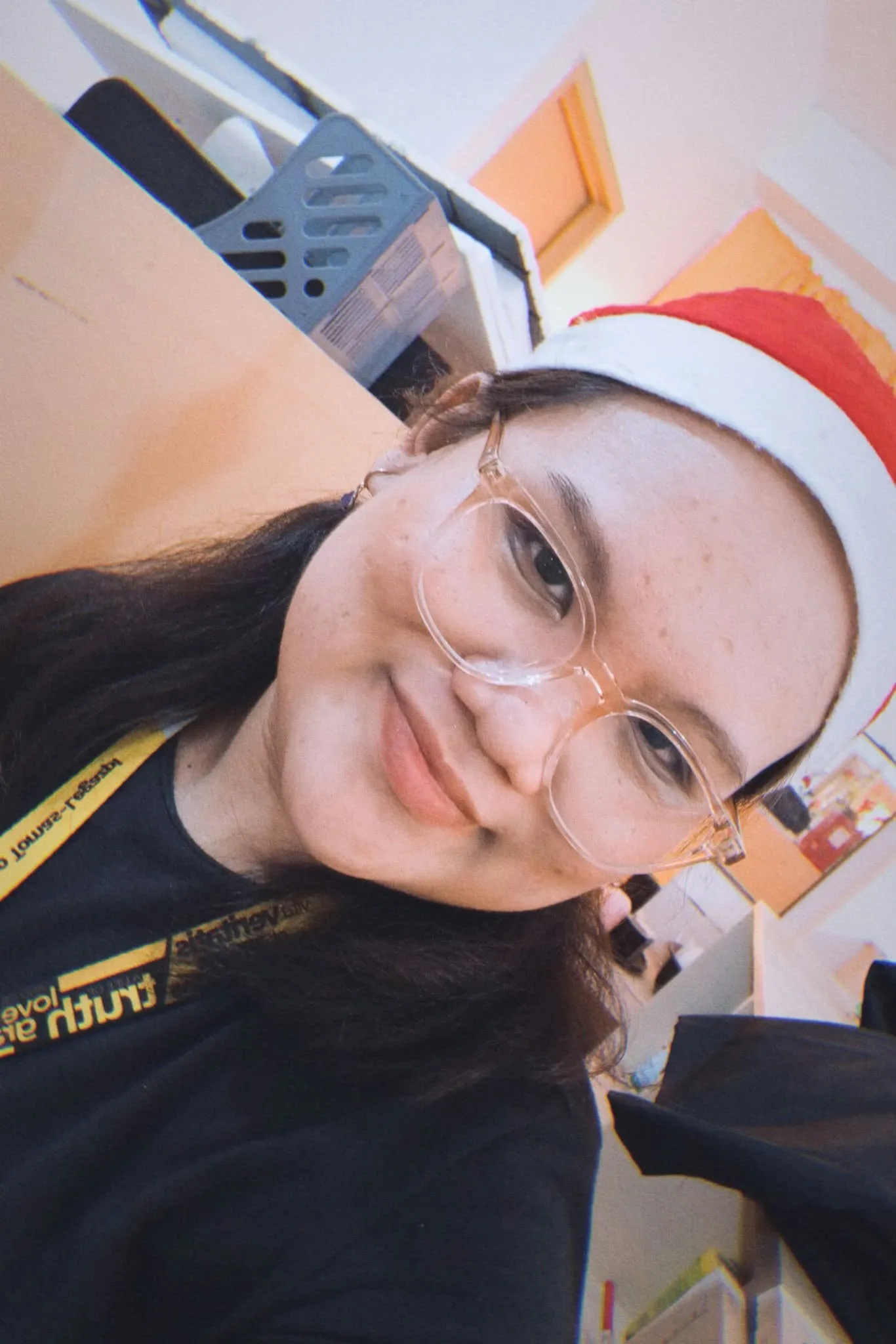 A selfie of a crew member in a Santa hat and glasses.