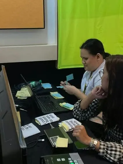 Two crew members preparing cue cards at the console.