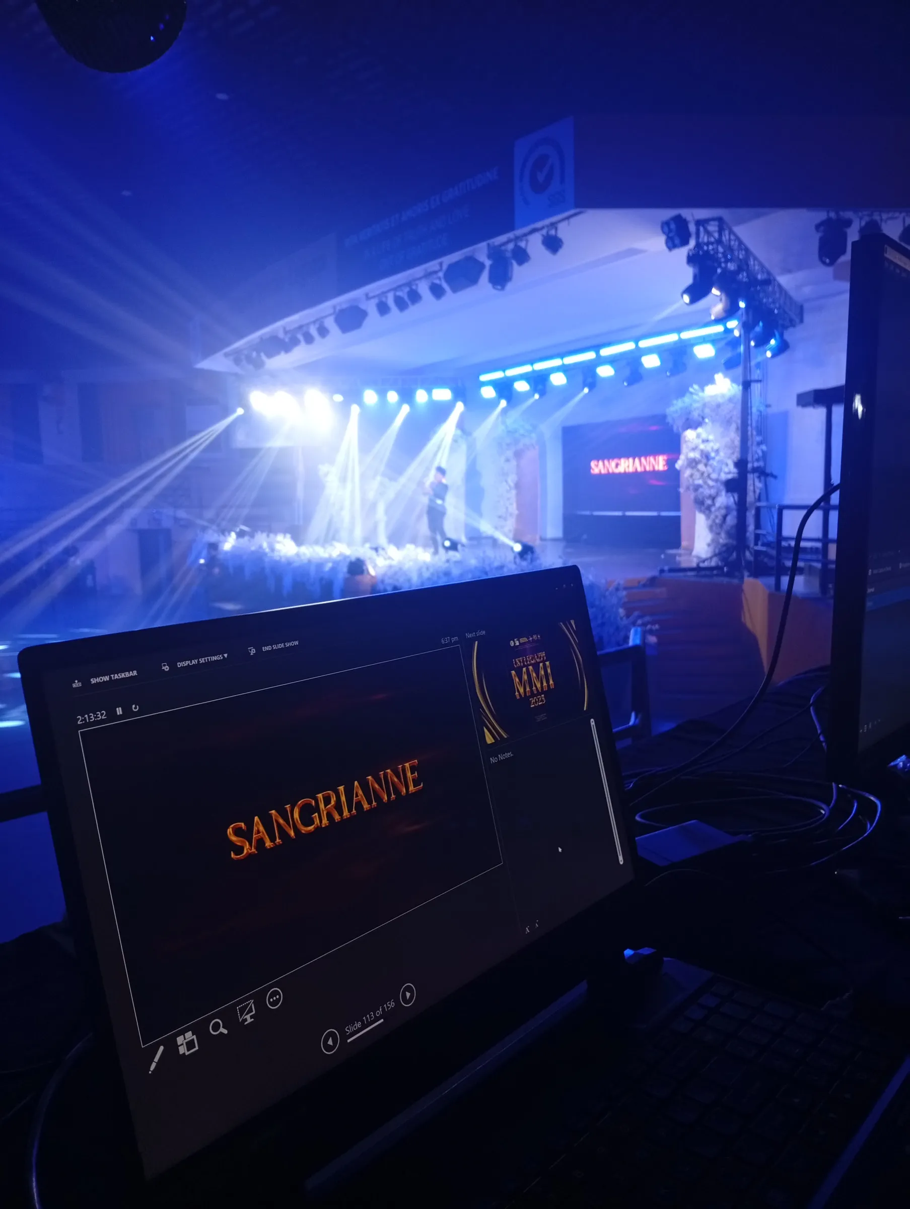 The lit stage seen from the control booth, a laptop in front of it.