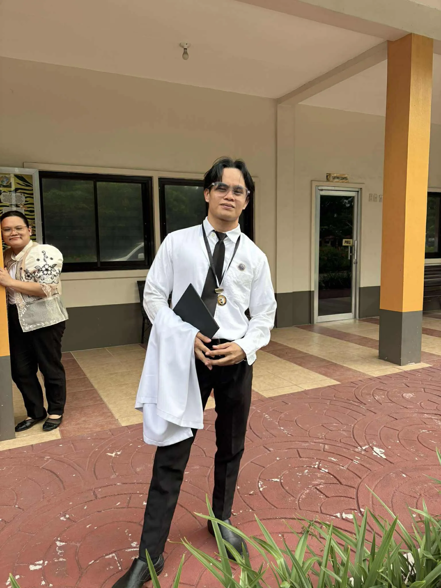 An actor in a white lab coat posing in the corridor.