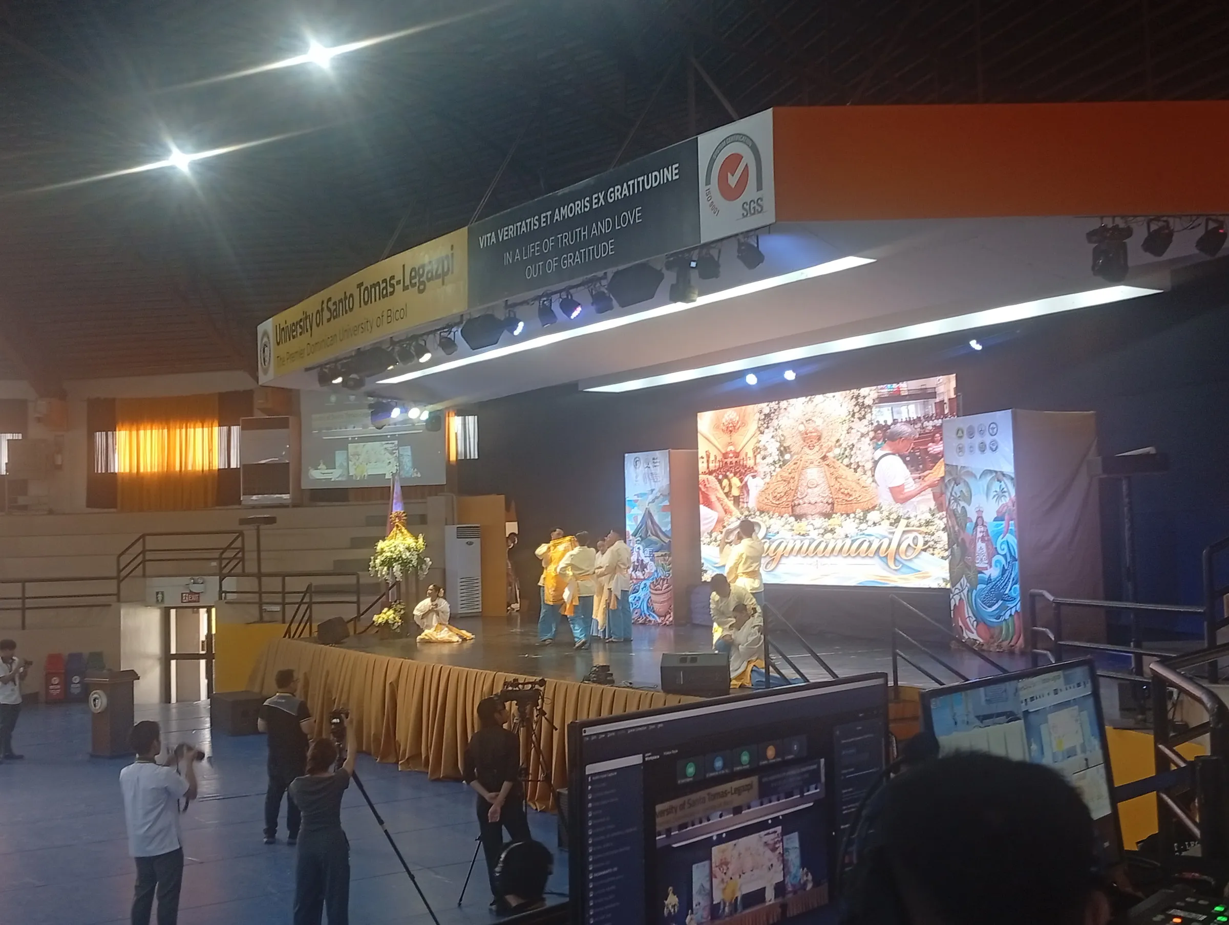 The Madya Bayle stage and its screens seen past the production laptops.