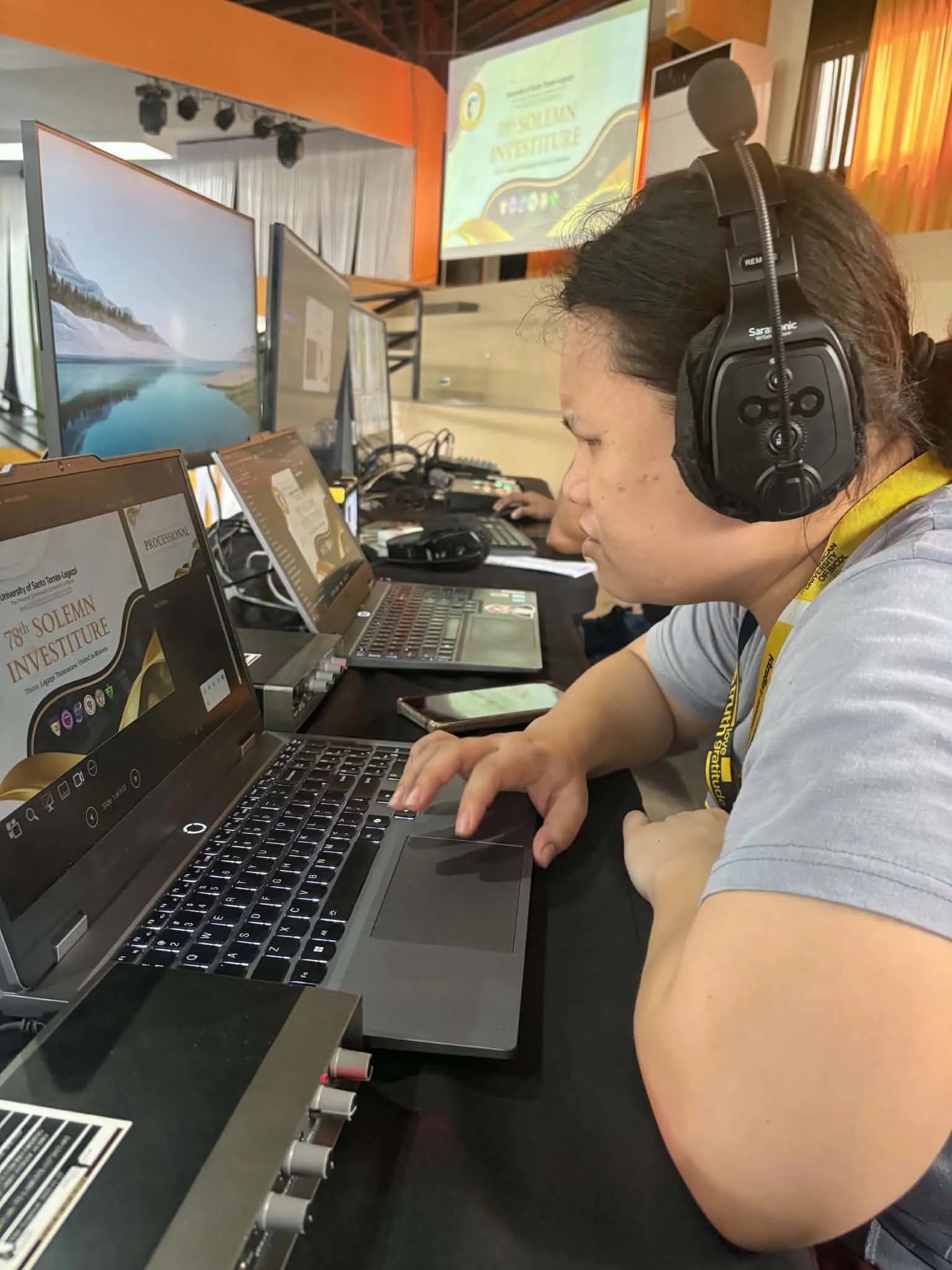 A crew member in headphones working the production laptop.