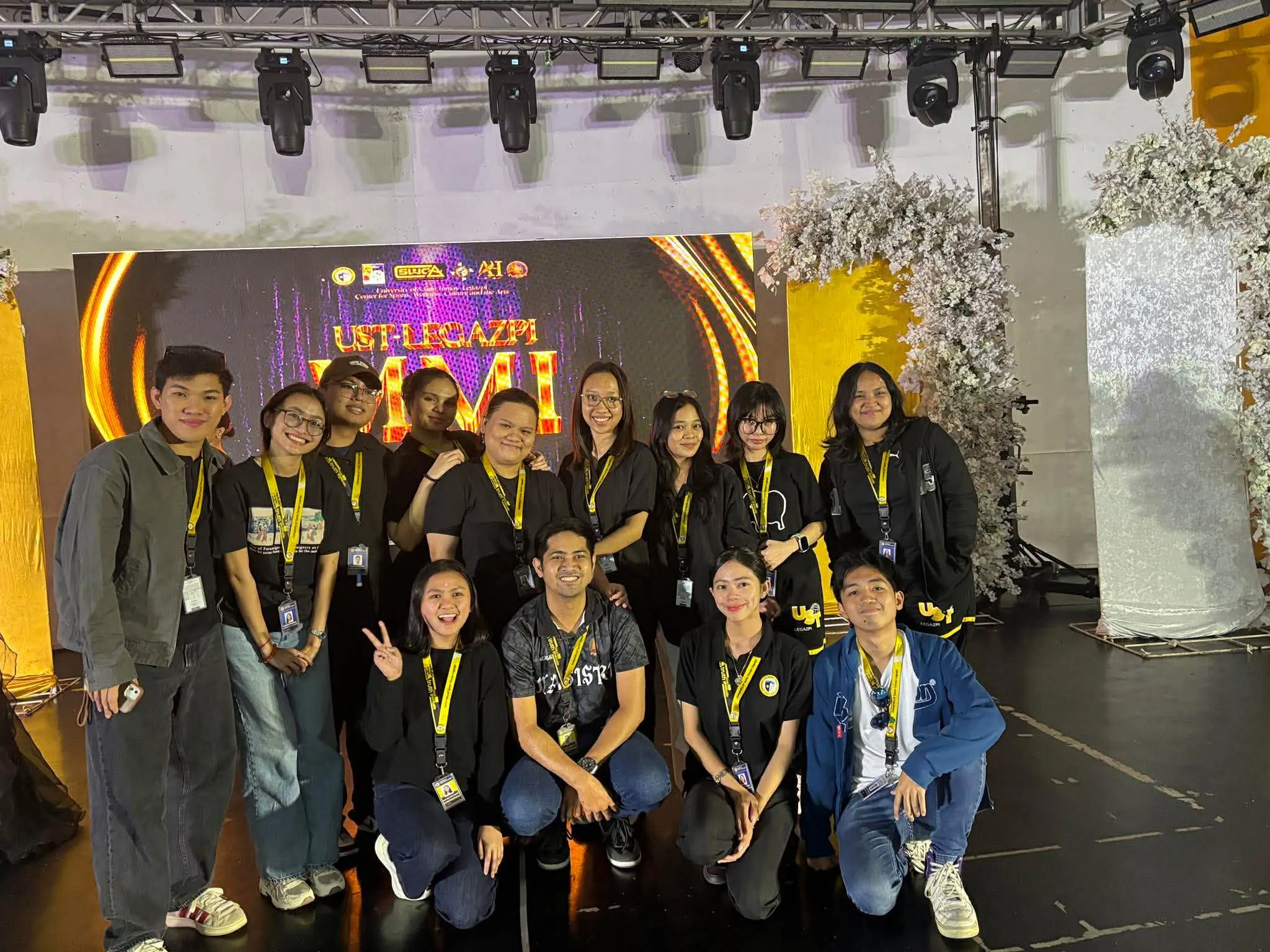 The production crew posing in front of the UST-Legazpi MMI stage backdrop.