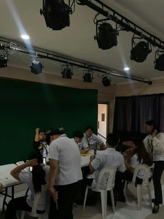 Students setting up in a studio under stage lights.