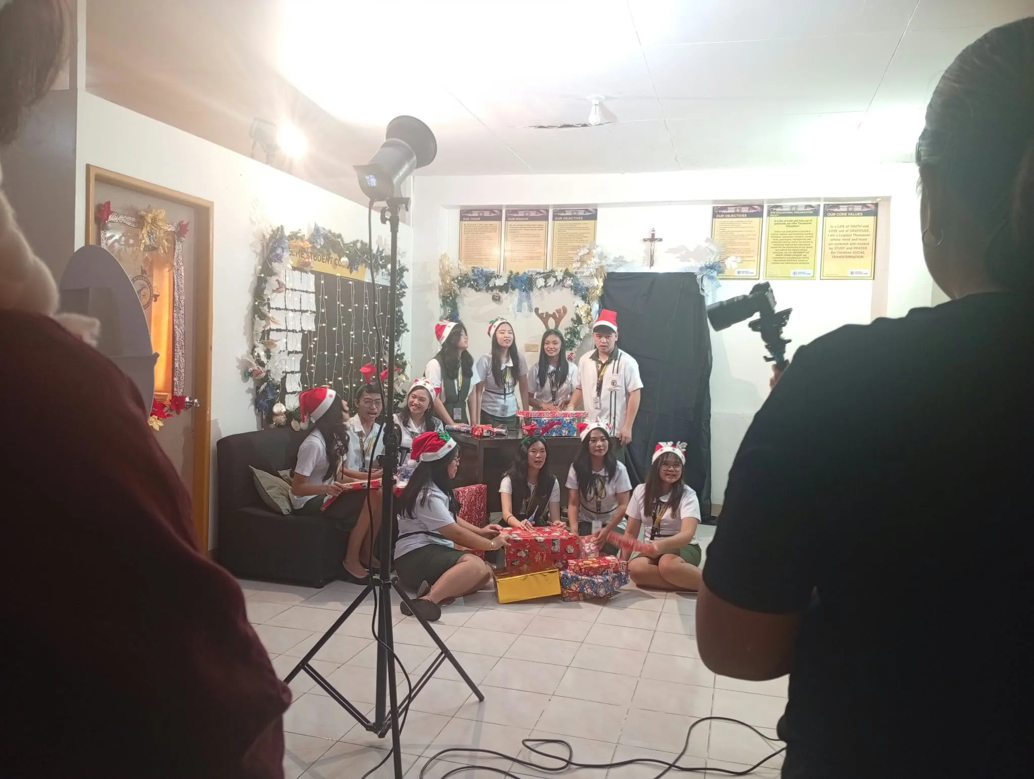 A Christmas shoot set up under studio lights, the group posing in Santa hats.