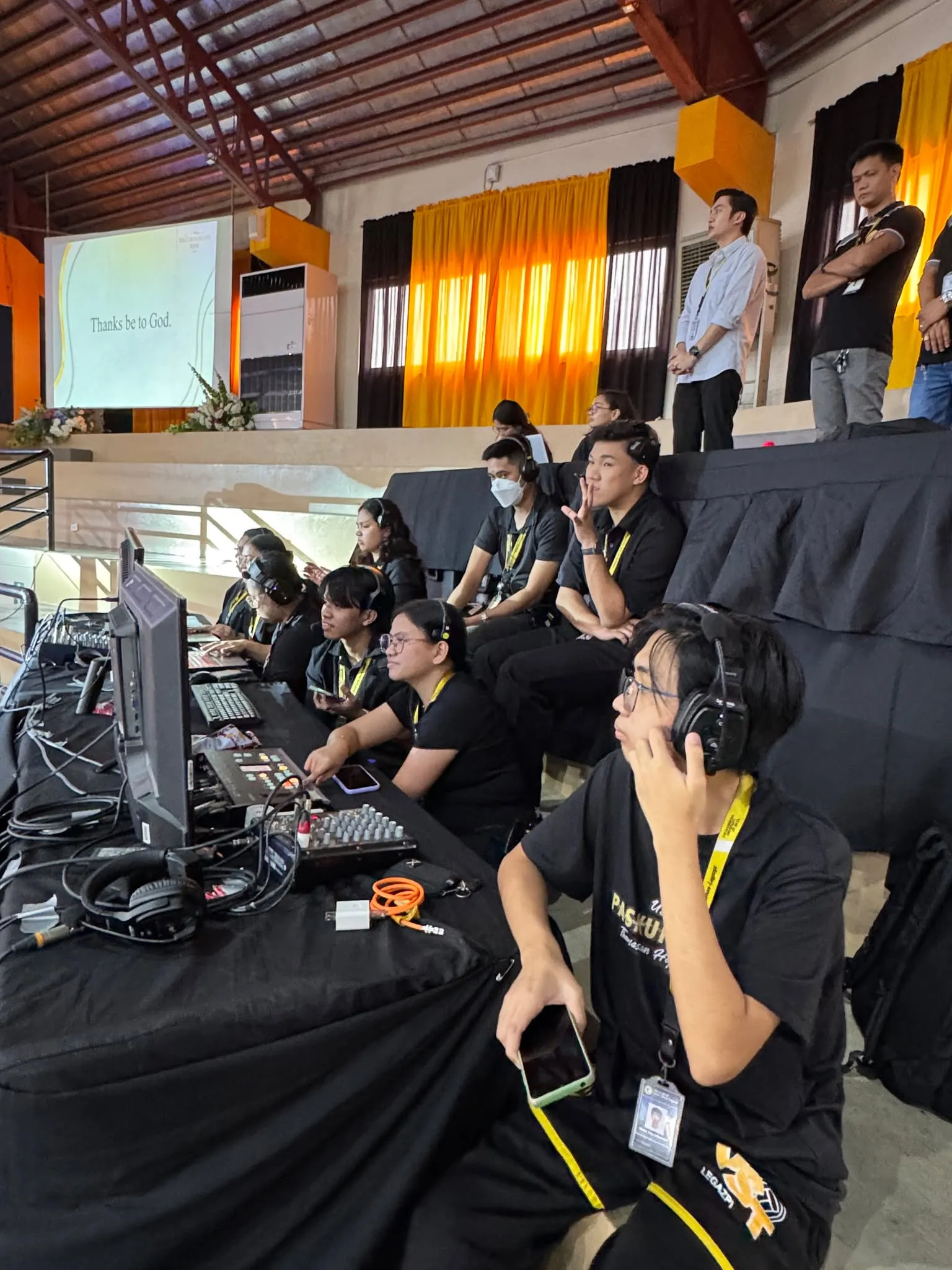 Crew in headsets at the production desk in the gym.