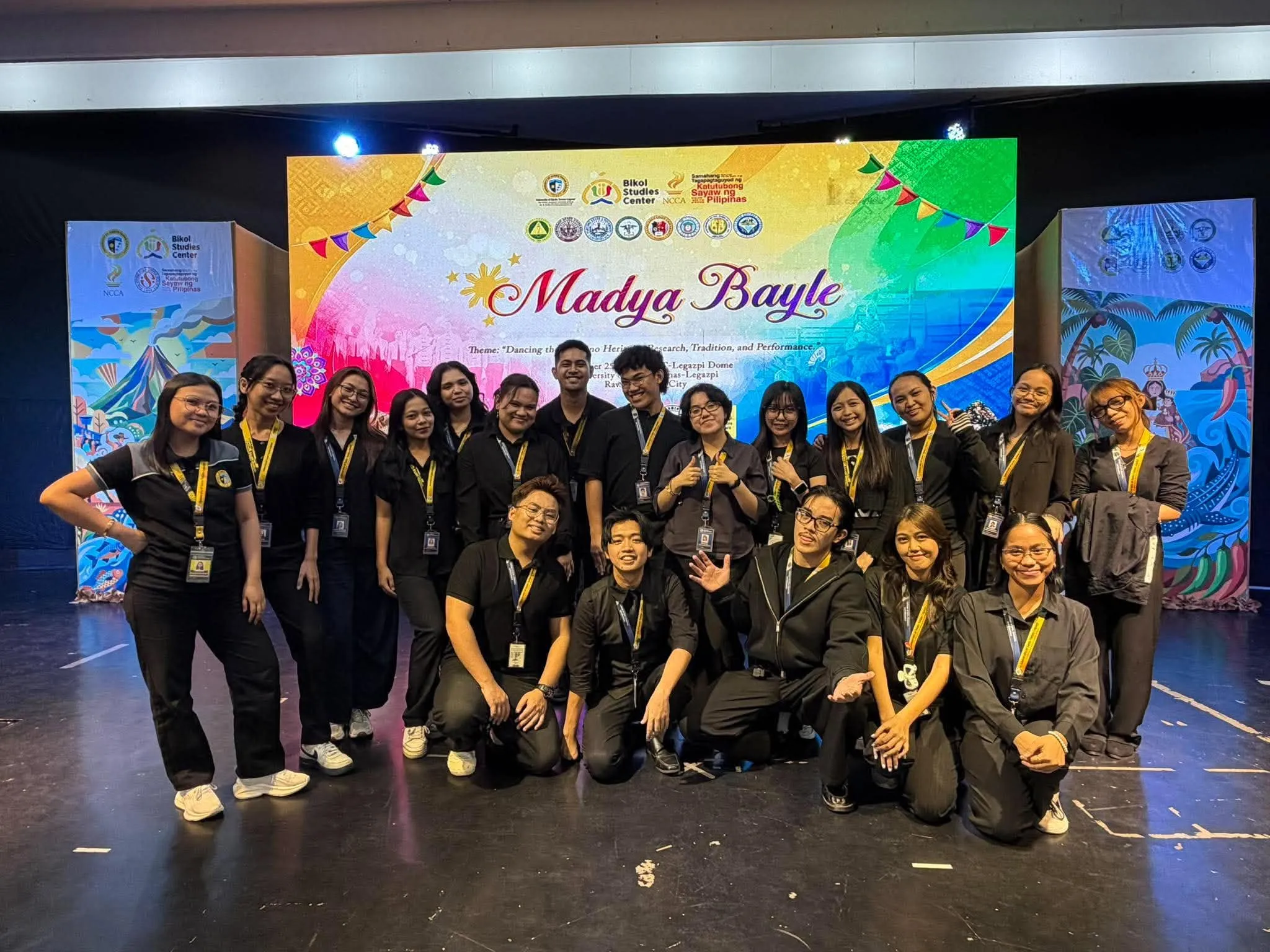 The production crew posing in front of the Madya Bayle backdrop.