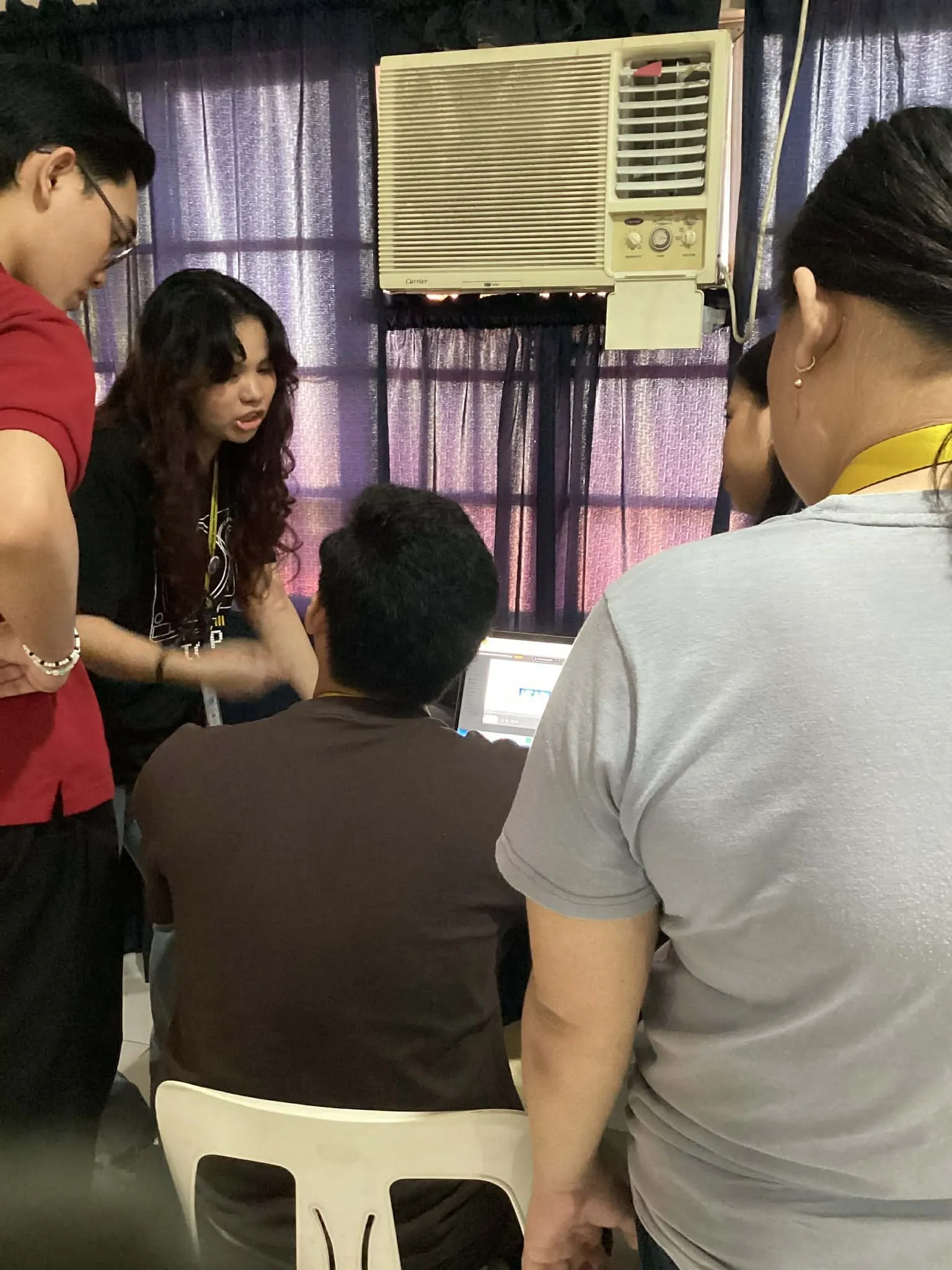 Students gathered around a laptop during a class production.