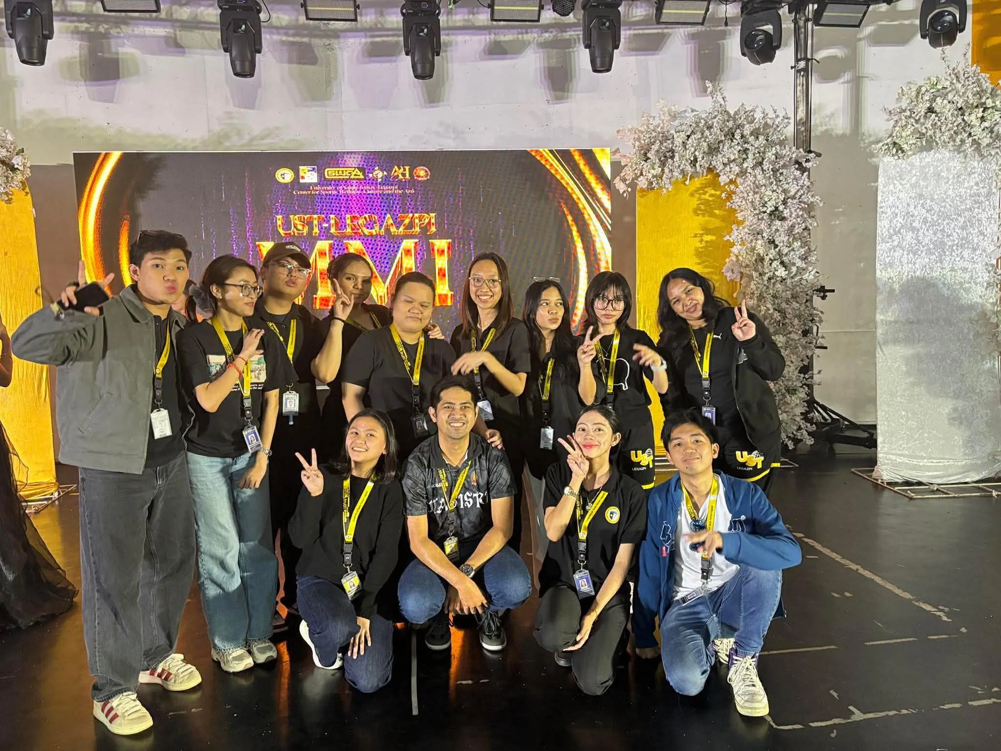 The production crew posing in front of the MMI stage backdrop, a third take.