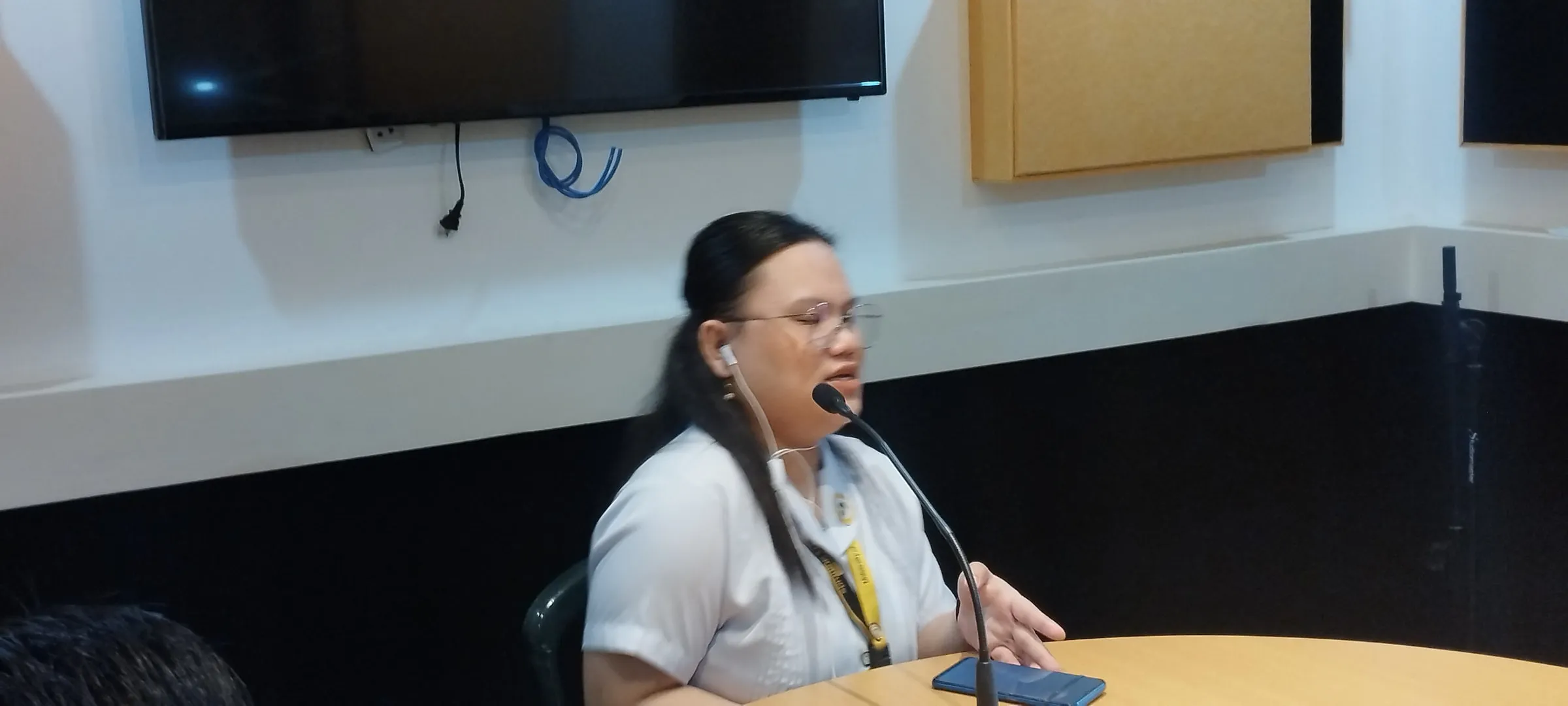 A student speaking into the studio microphone.