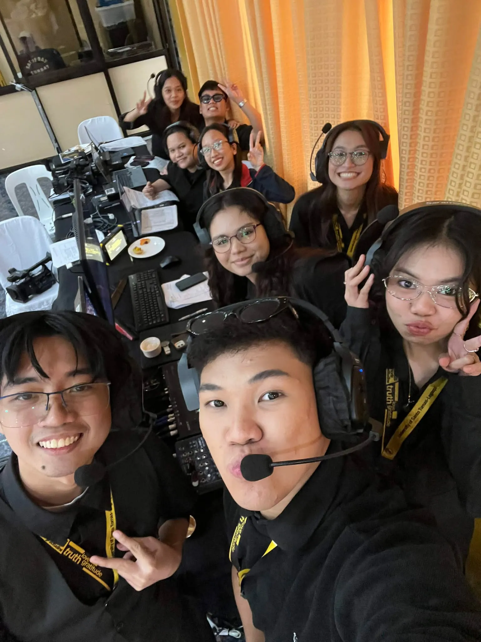 A group selfie of the crew in headsets at the production desk.