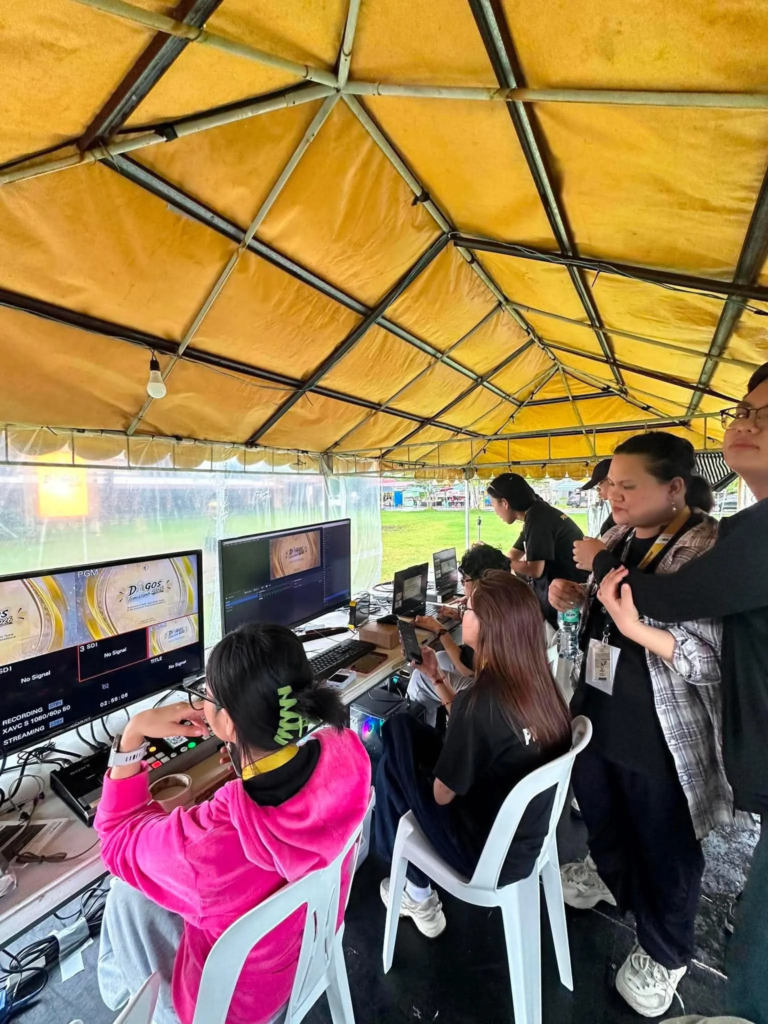 Crew members at the production tables under the tent.