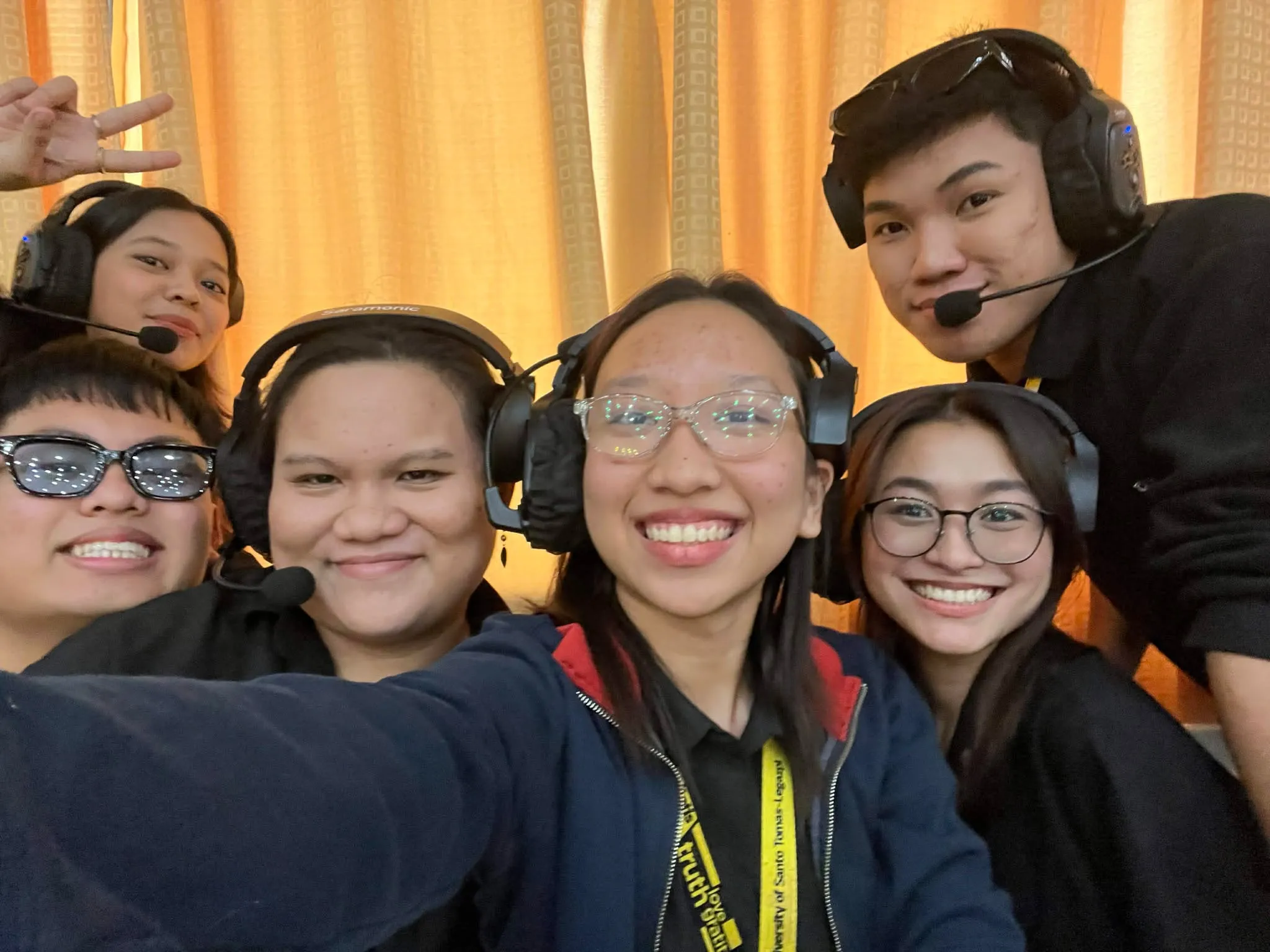 A close group selfie of four crew members in headsets.