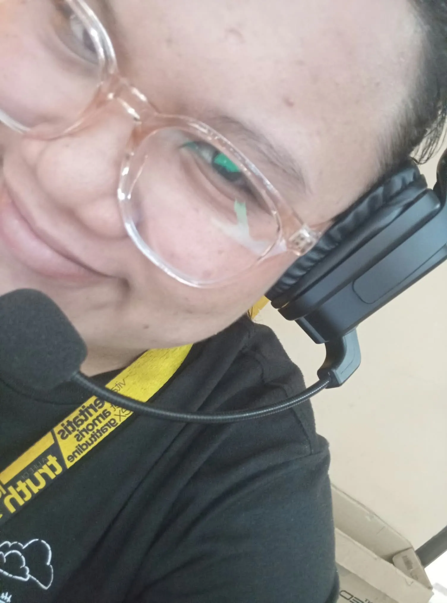 A close-up selfie of a crew member in glasses and a headset.