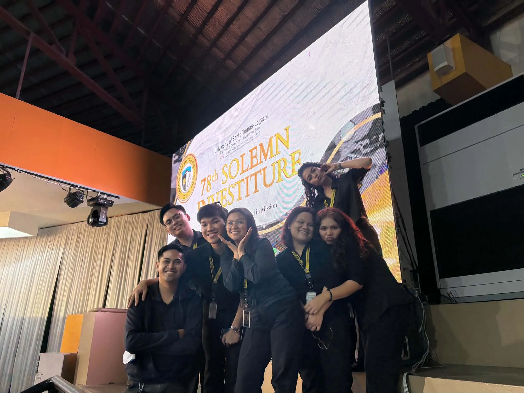 The crew posing in front of the Solemn Investiture screen.