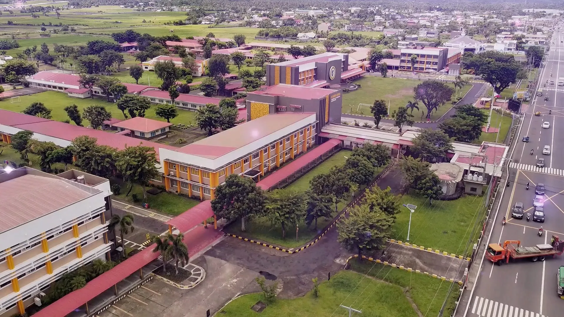 A still from Hearth, the UST-Legazpi campus seen from the air beside the highway.