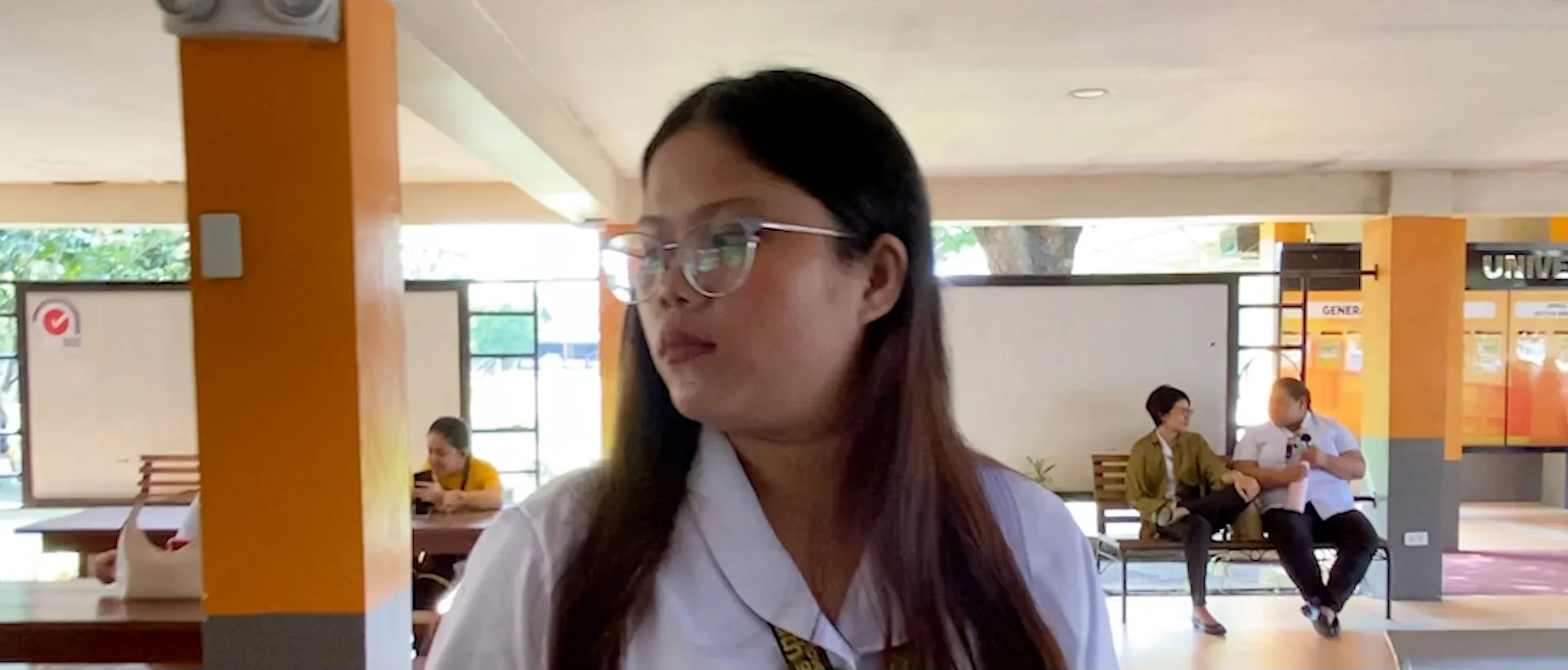 A still from Tugon, a student in a white uniform in a school hallway.
