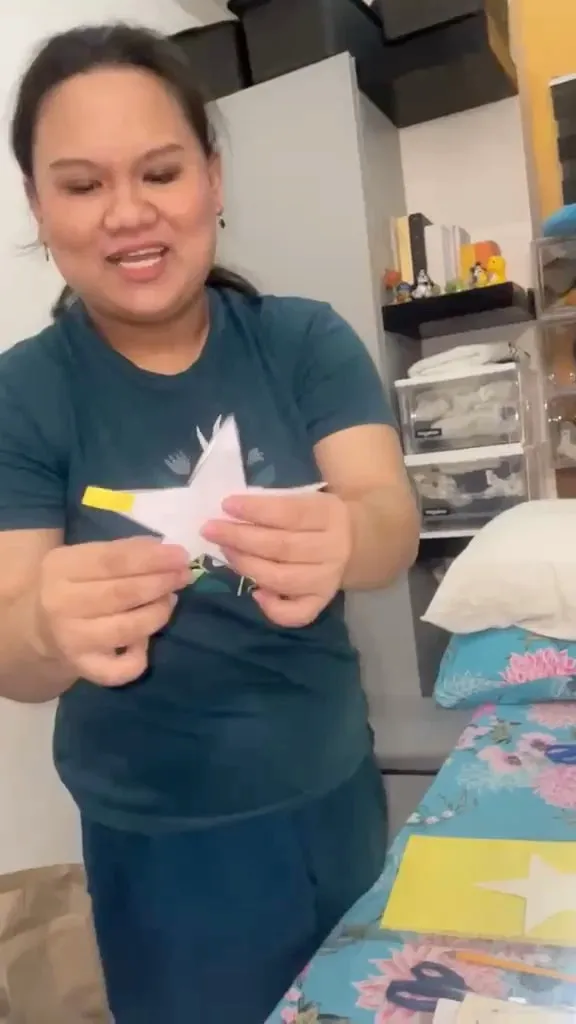 A short video of a crew member cutting out paper stars for the Christmas ID and holding them up to the camera.