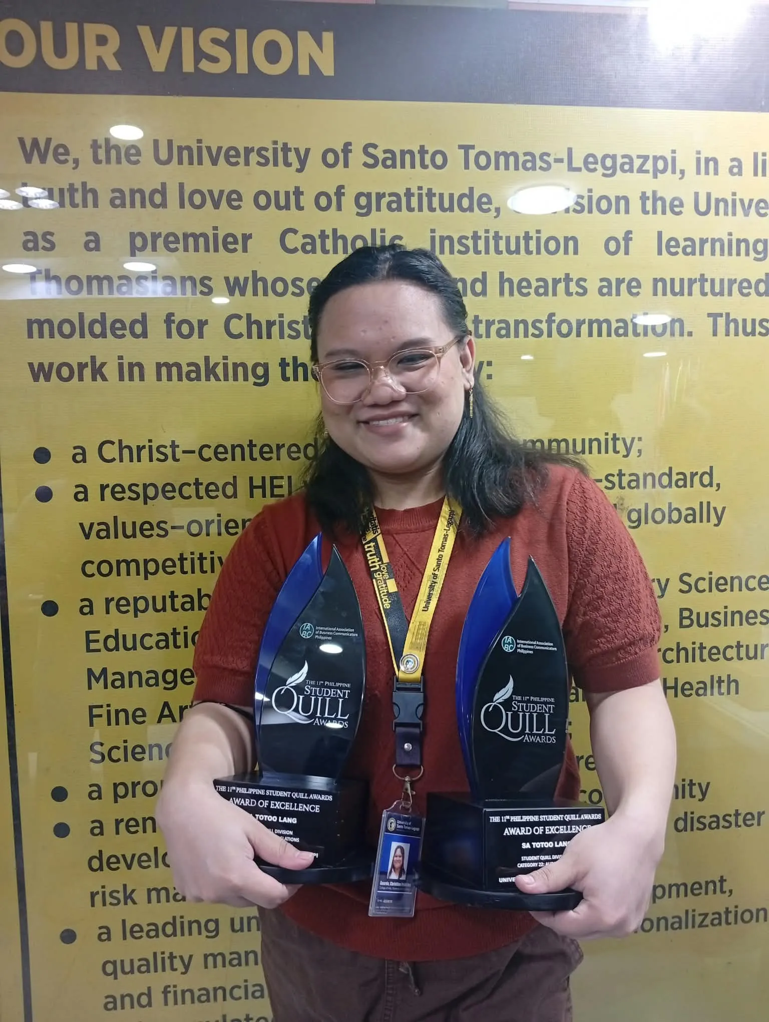 Christine holding two Quill trophies, another take.